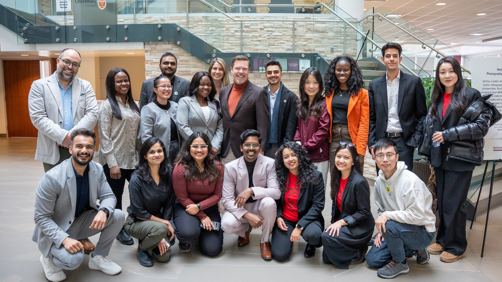 A group of MBA students and faculty, smiling and posing together.