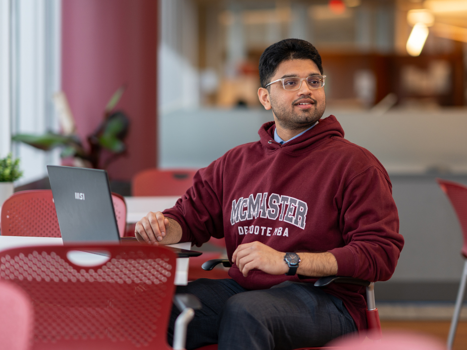 A smiling student working on a laptop.